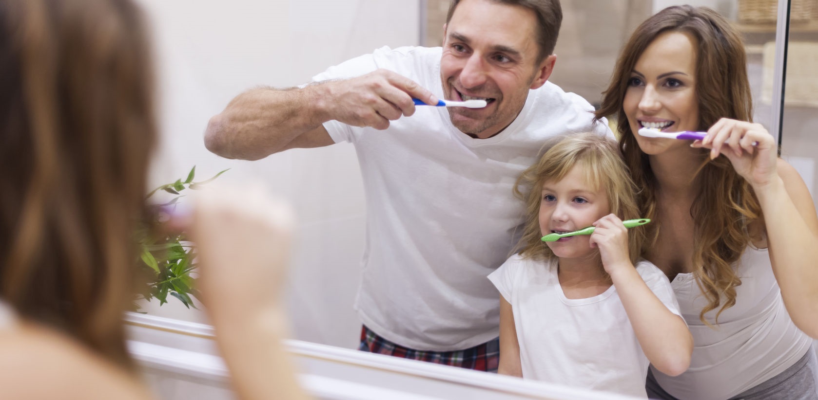 Семья в ванной чистят зубы